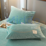 taies d'oreiller en velours polaire vert jade sur lit avec decoration en verre