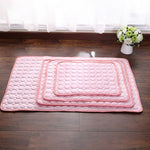 tapis rafraîchissant rose décliné en toutes les tailles, disposés sur un carrelage brun