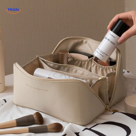trousse de voyage beige ouverte avec son contenu affiché, organisation intérieure spacieuse