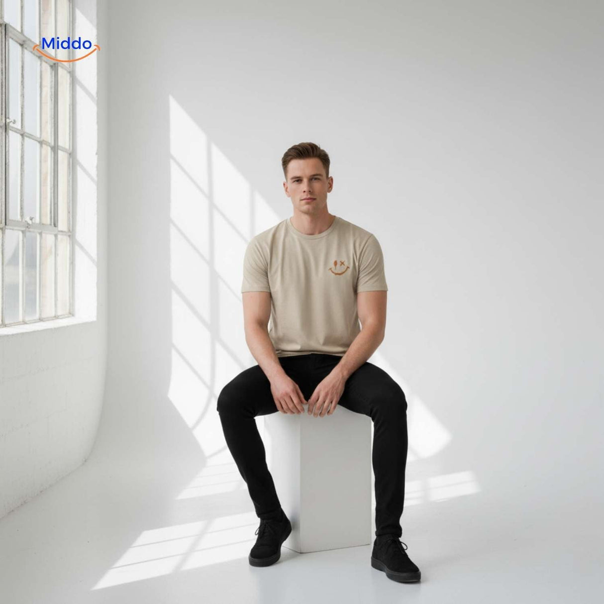 t-shirt beige porté par un homme assis, style minimaliste épuré