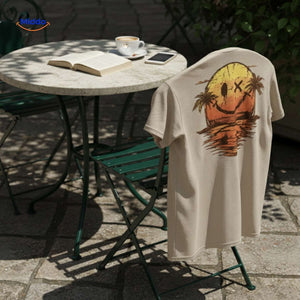 t-shirt beige avec imprimé smiley posé sur une chaise en extérieur