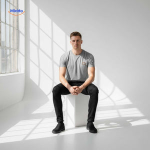 t-shirt gris porté par un homme assis dans un studio minimaliste, pose naturelle