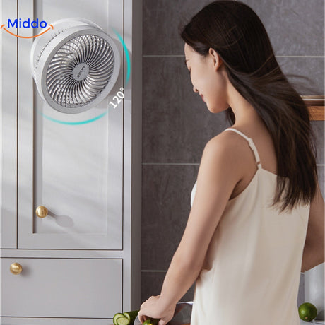 femme profitant de la fraîcheur du ventilateur dans la cuisine, cheveux au vent